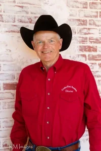 PIcture of Doug Smith - in Red oxford with Crooked river logo on it - and black cowboy hat